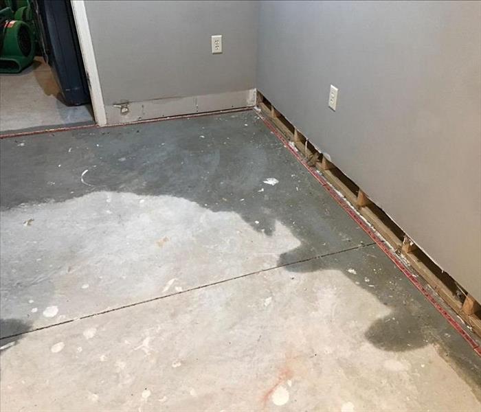 Wet concrete floor and removed baseboards 