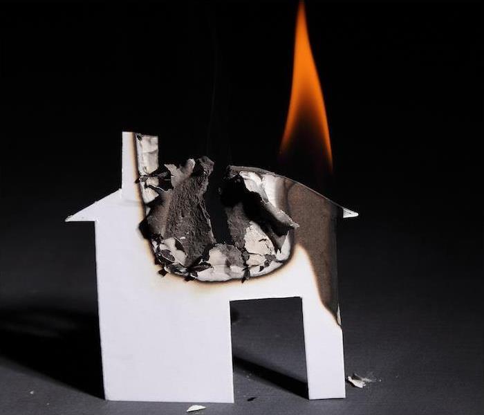 A small paper house burning